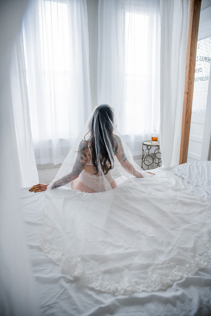 BoudoirByStephanieNivens_White_Bridal_lingerie_veil_woman_sitting_on_the_bed
